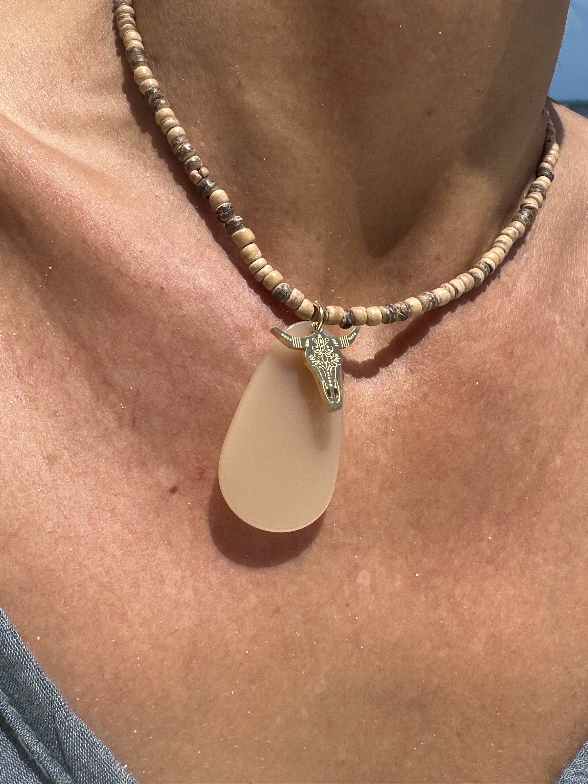 collar corto de cuentas en beige y marrón acabado con detalle de piedra beige y  búfalo en dorado Neandnu