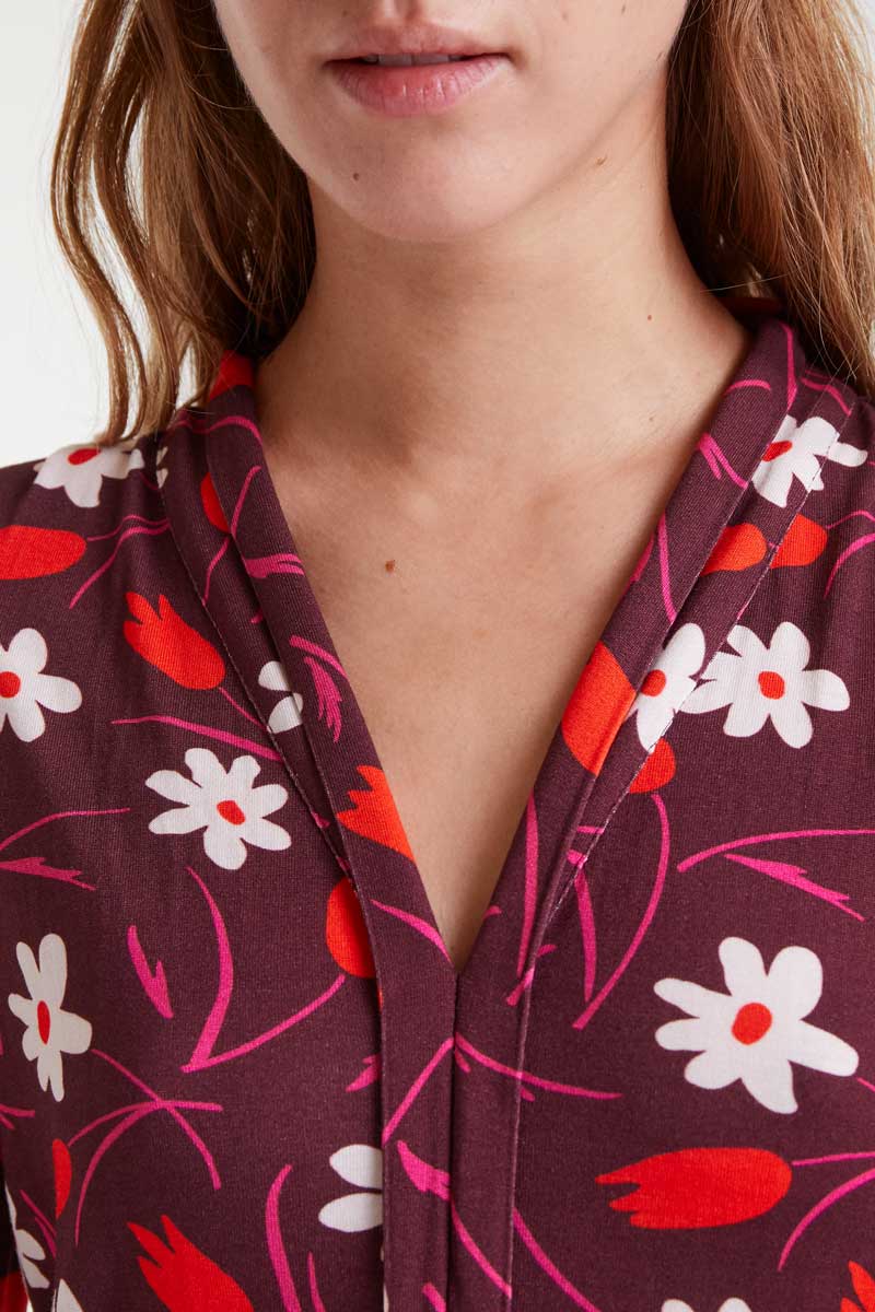 Vestido maxi manga larga estampado floral de tulipanes y margaritas sobre fondo morado cuello pico cierre frontal con botones ocultos corte horizontal con detalle de pliegues Neandnu