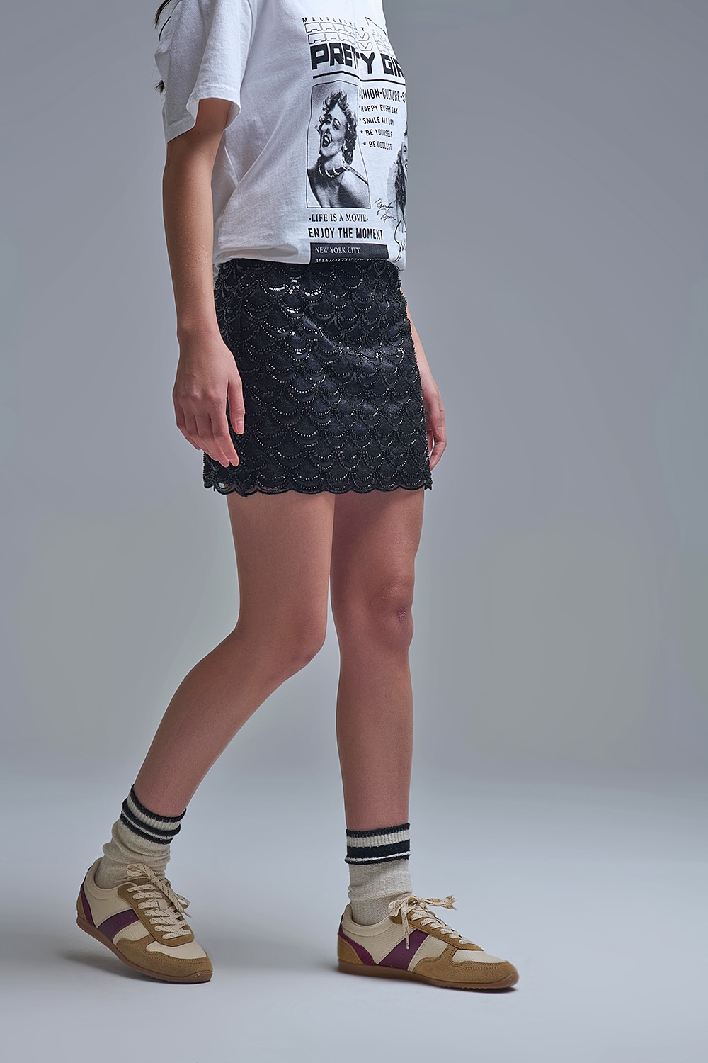 falda mini color negro cierre lateral con cremallera oculta y forro interior diseño de lentejuelas negras rematado con dobladillo festoneado Neandnu