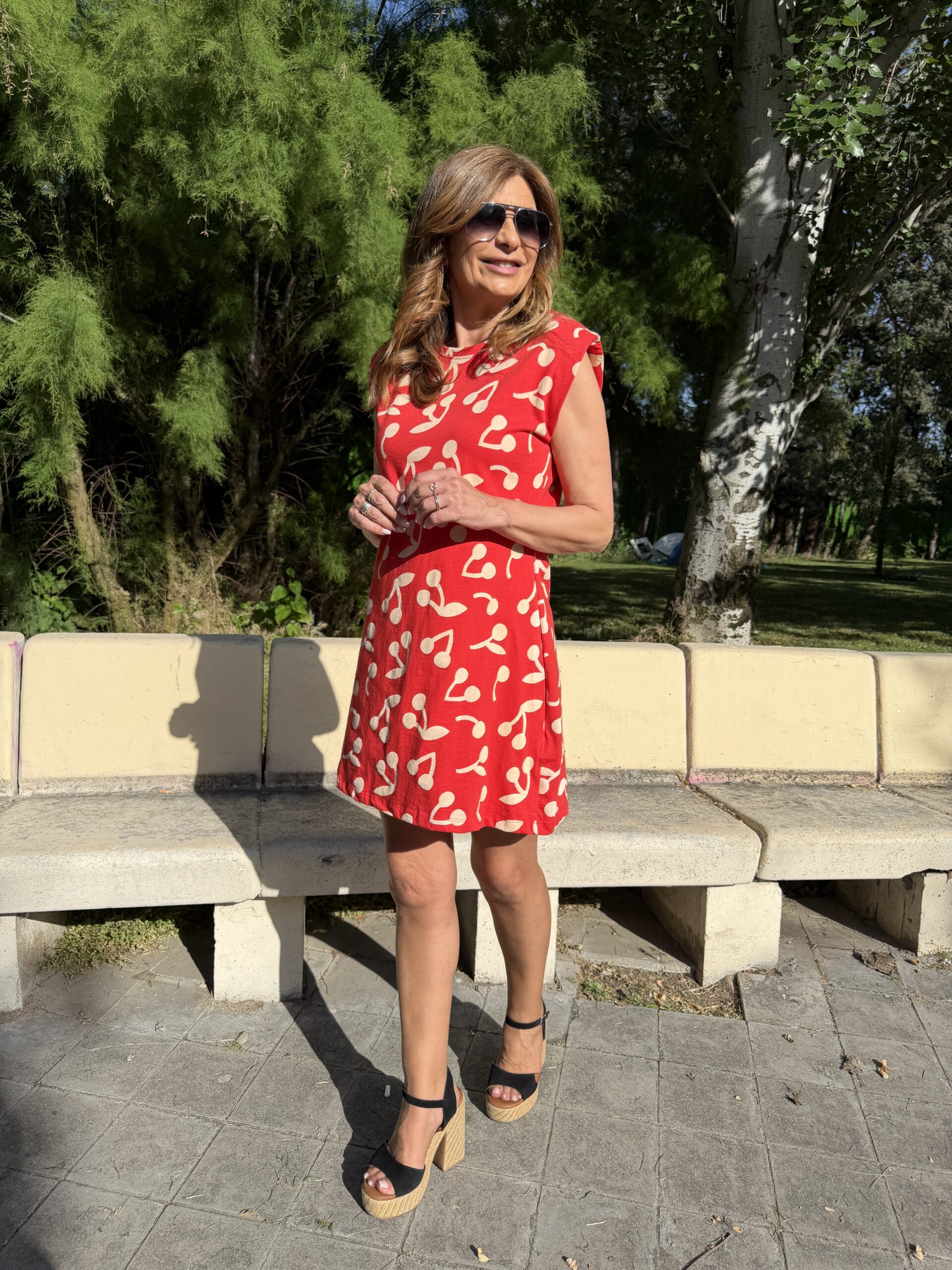 Vestido mini sin mangas en estampado de guindas de color blanco sobre fondo rojo cuello redondo y corte fluido Neandnu