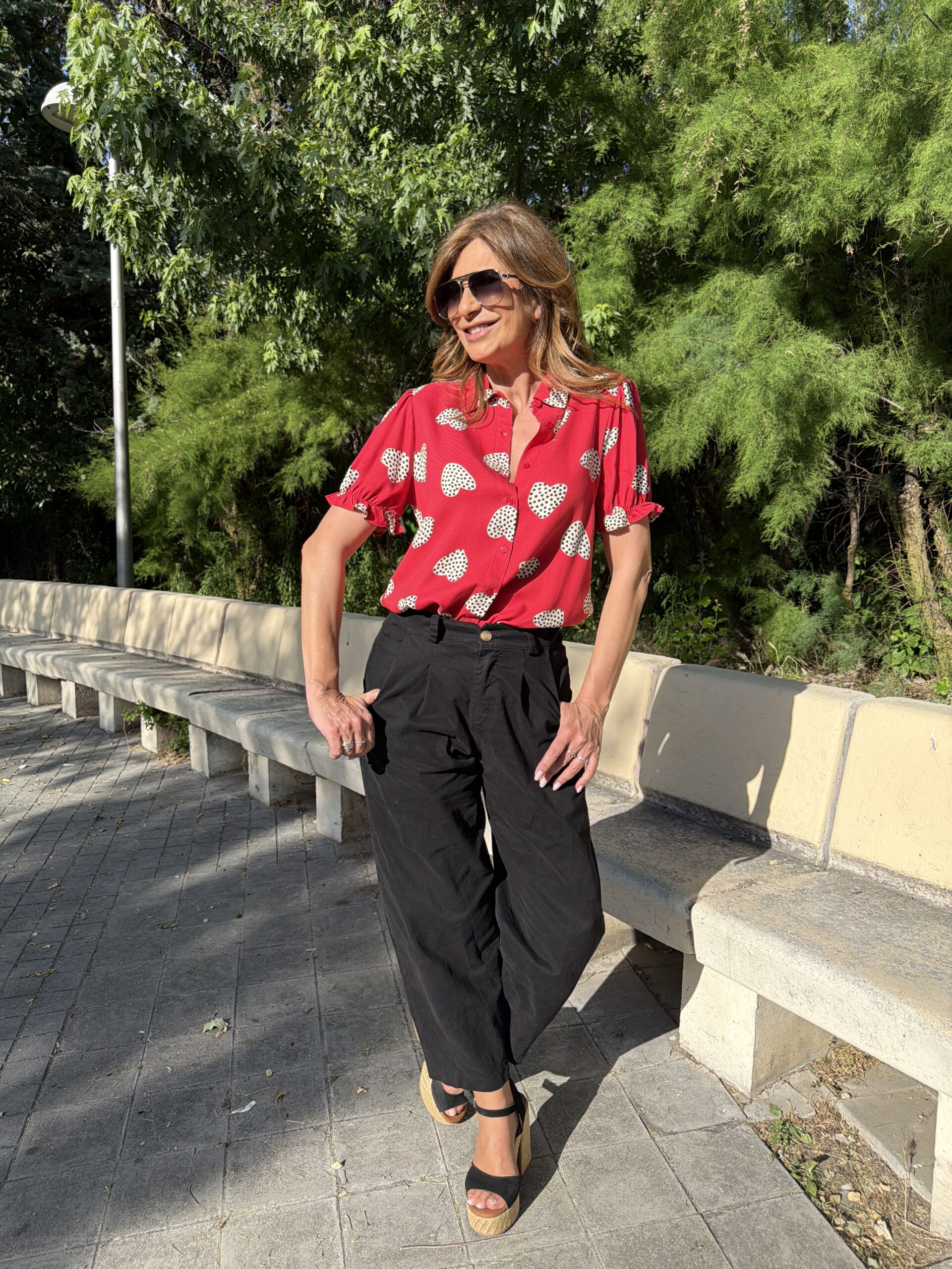 Camisa manga corta ligeramente abullonada con volante cuello con solapa y cierre frontal con botones de color rojo estampado de corazones blancos con lunares negros sobre fondo color rojo Neandnu