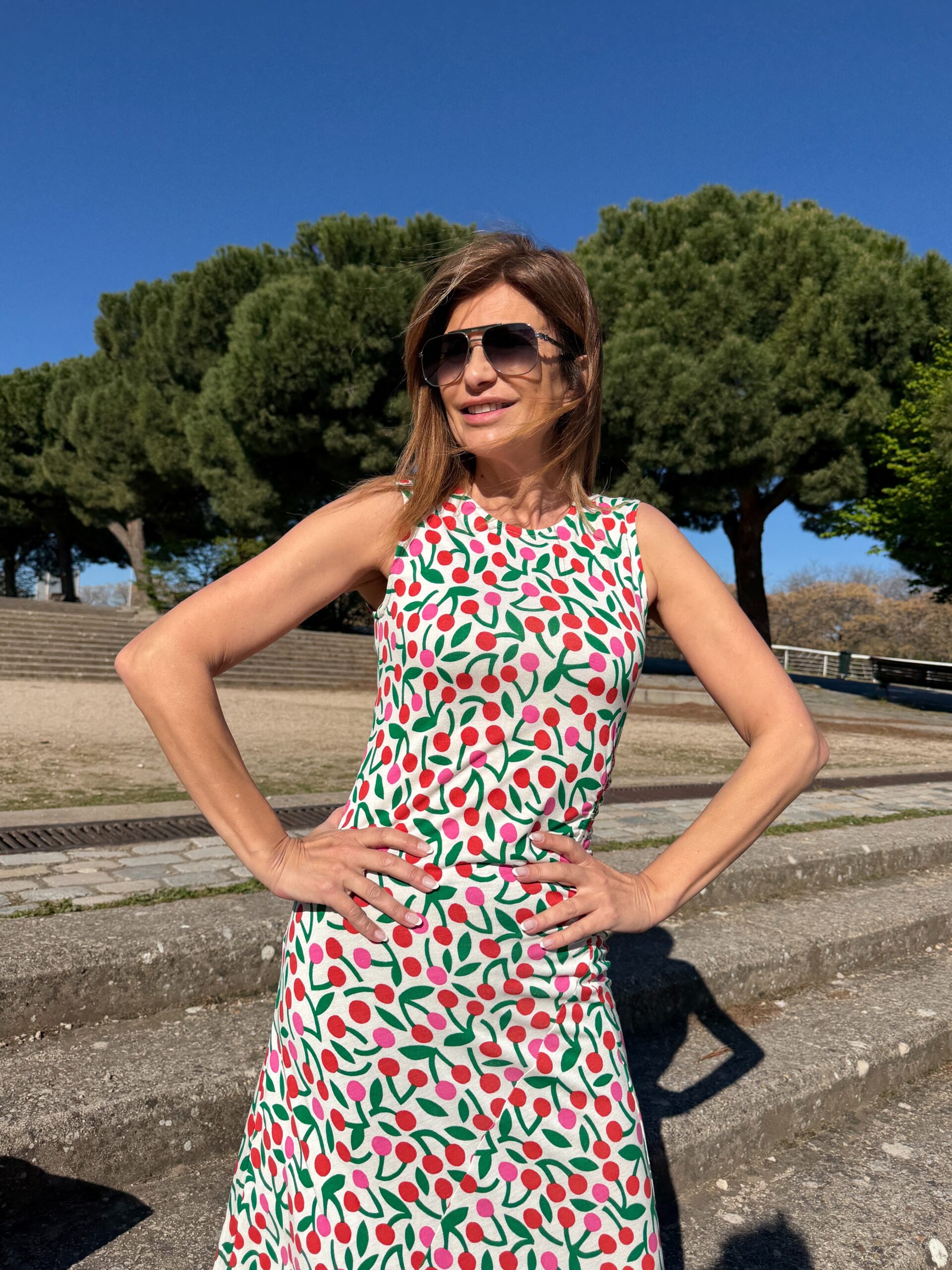 Vestido maxi sin mangas estampado guindas sobre fondo blanco cuello redondo y sin mangas detalle de ajuste elástico en la cintura y cierre posterior con botón oculto Neandnu