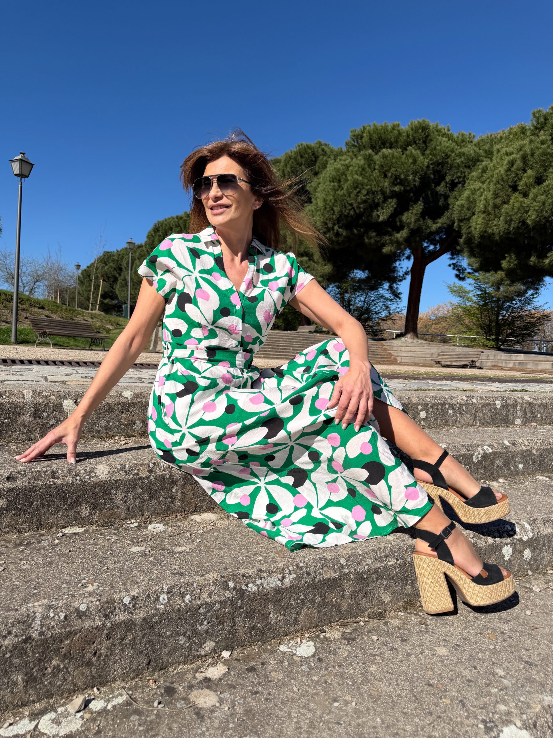 Vestido largo manga corta tejido crepé ligero cuello solapa escote pico cierre frontal con botones blancos cinturón para ajustar a la medida y bolsillos laterales estampado de hojas blancas sobre fondo verde y motivos redondeados en negro y rosa Neandnu