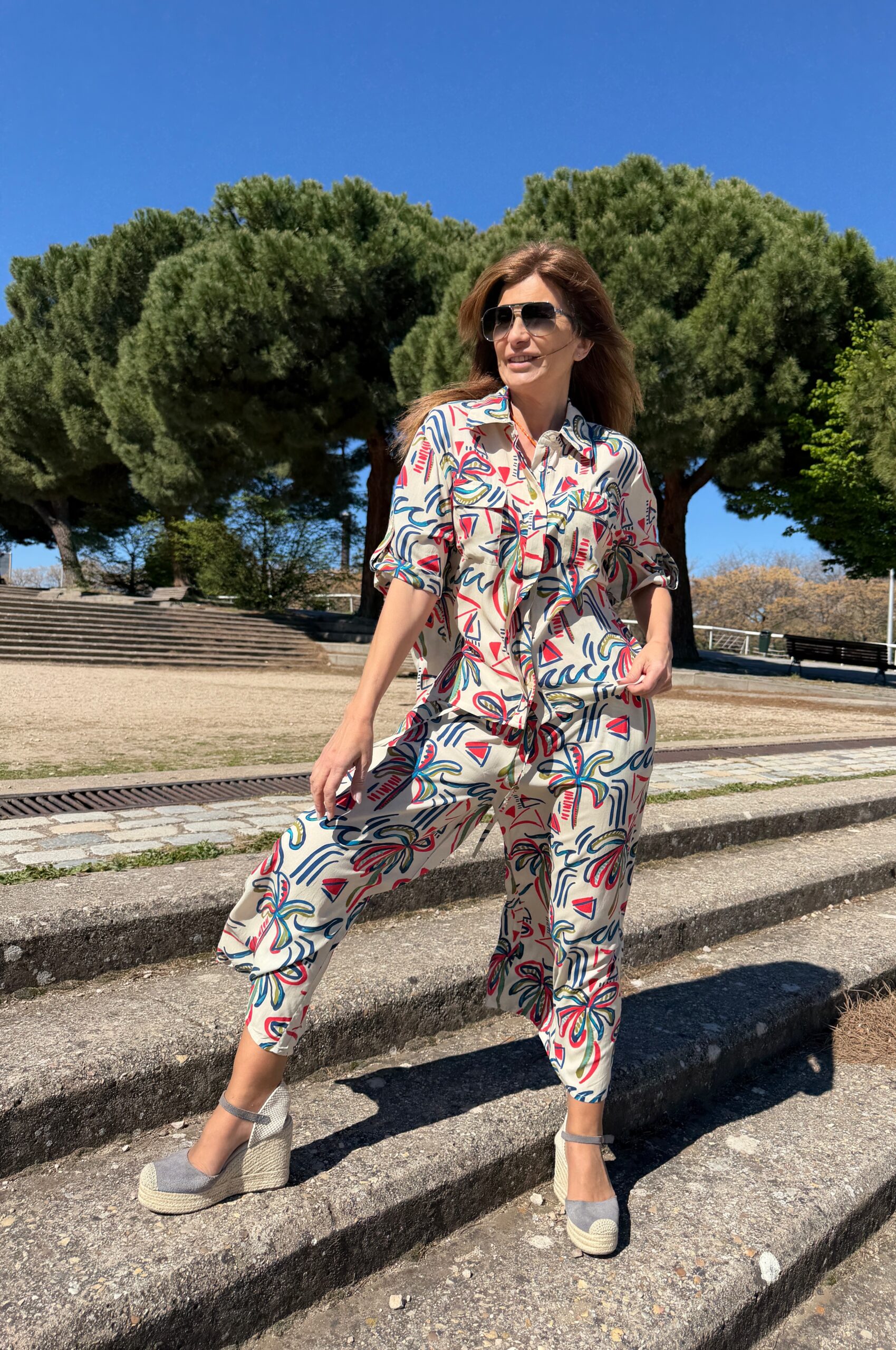 Camisa manga corta con dobladillo y cinta para fijar con botón cuello camisero y detalles de bolsillos con solapa en la parte del pecho estampado de trazos multicolor sobre fondo crudo Neandnu
