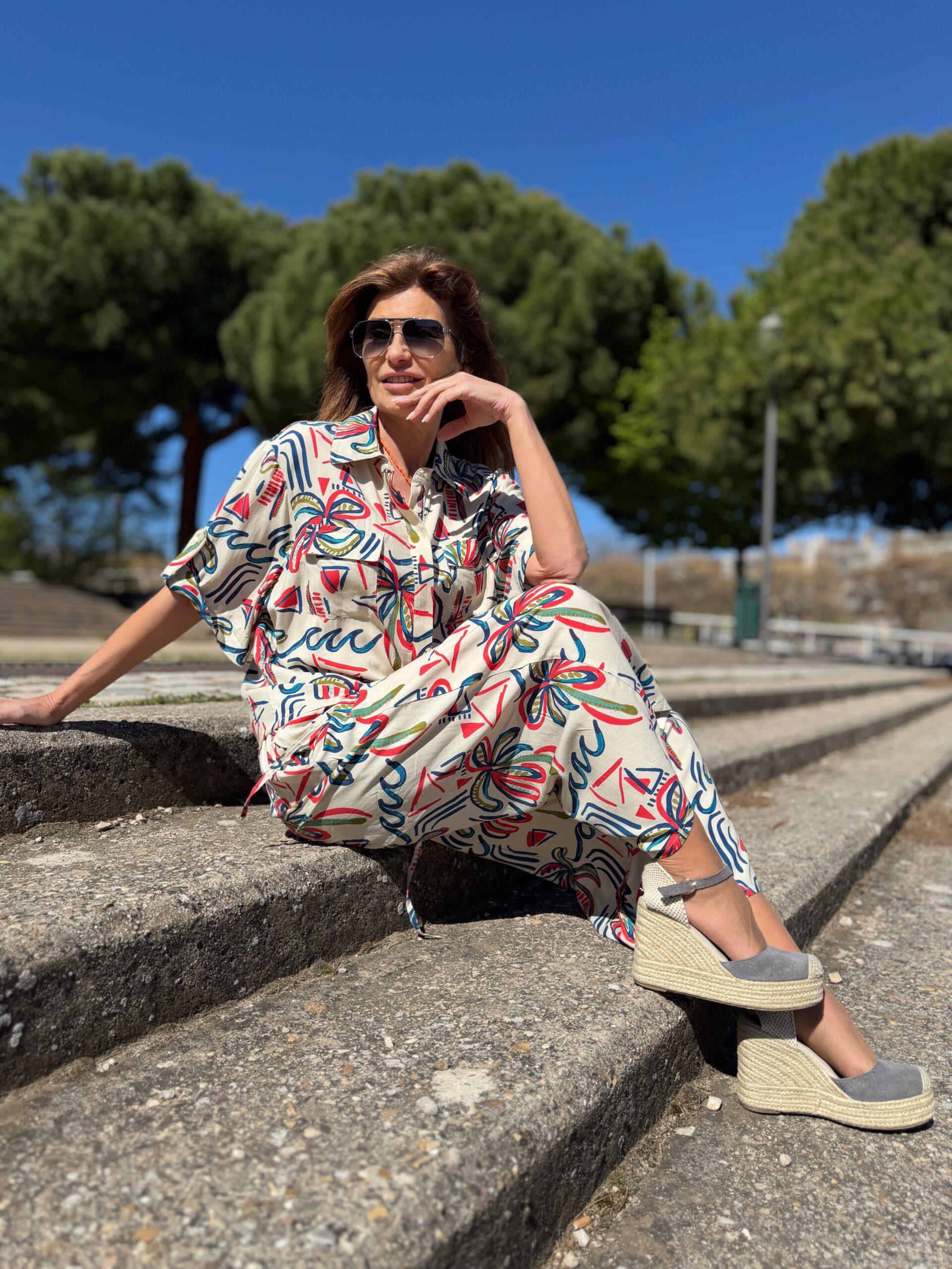 Camisa manga corta con dobladillo y cinta para fijar con botón cuello camisero y detalles de bolsillos con solapa en la parte del pecho estampado de trazos multicolor sobre fondo crudo Neandnu