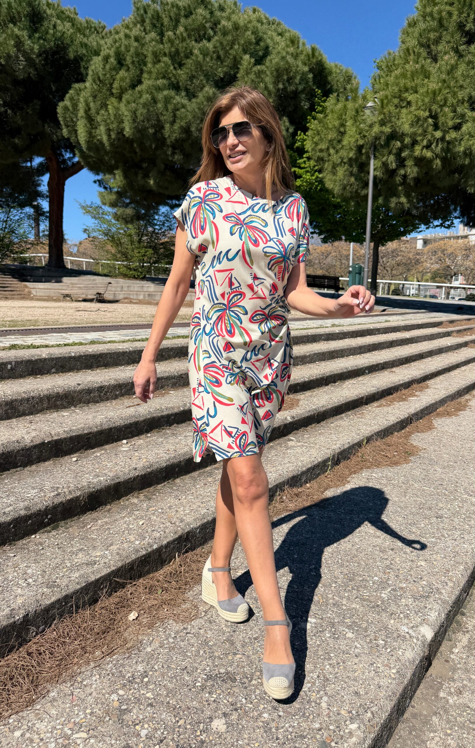 Vestido mini manga corta cuello redondo detalle anudado en el lateral de la cintura par ajustar a la medida y cierre con botón en la parte de atrás estampado de trazos multicolor sobre fondo crudo Neandnu