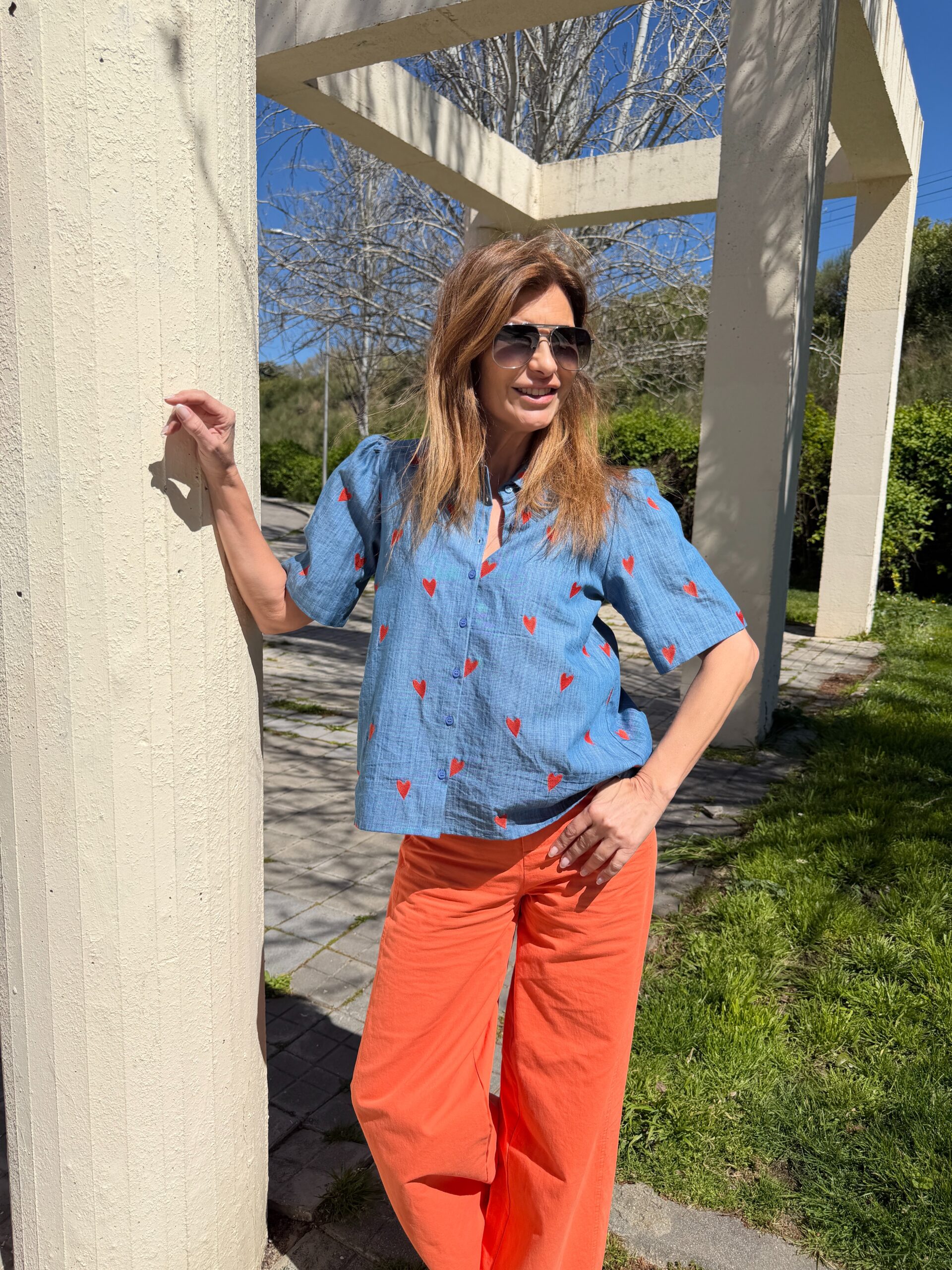 Camisa algodón chambray azul oscuro y estampado de corazones de color rojo cuello con solapa y manga ligeramente abullonada 3/4. y cierre frontal con botones de color azul Neandnu