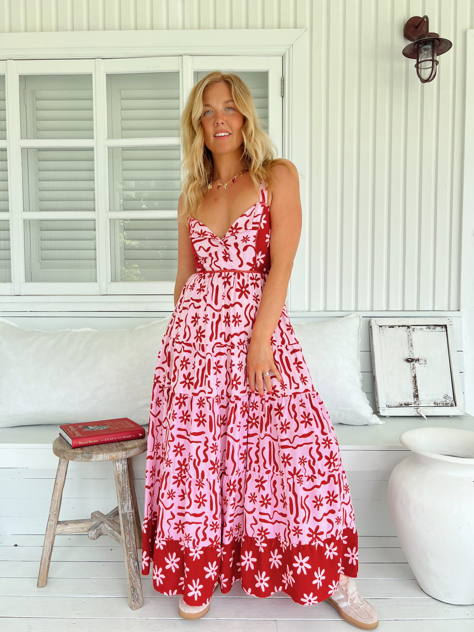 Vestido maxi boho tirante fino escote tipo bustier y falda larga de paneles escalonados y detalle de borde decorativo en el bajo estampado en contraste rojo coral y rosa pastel con motivos florales y ornamentales Neandnu